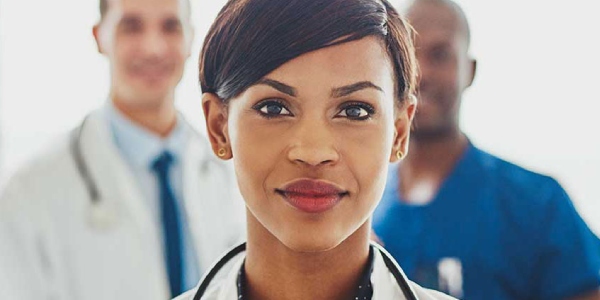 Provider with a stethoscope around neck with two additional providers flanking them.